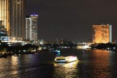 Bangkok night scene with high rise buildings and a ferry boat on the Jao Praya River.jpg