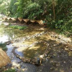 Water pools with a heart-shaped rock formation and some Nipa huts